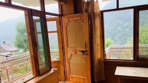 Une pièce en bois avec une grande fenêtre, une porte et un banc.