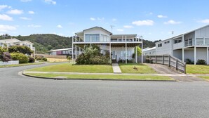 A modern two-story residential building with a flat roof, a covered porch, and a small front yard with a pathway leading to the entrance. - Seaview Apollo Escape (Apollo Bay)