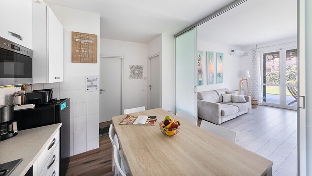 Eine moderne Küche mit Holztisch, Obstschale und Essbereich.
