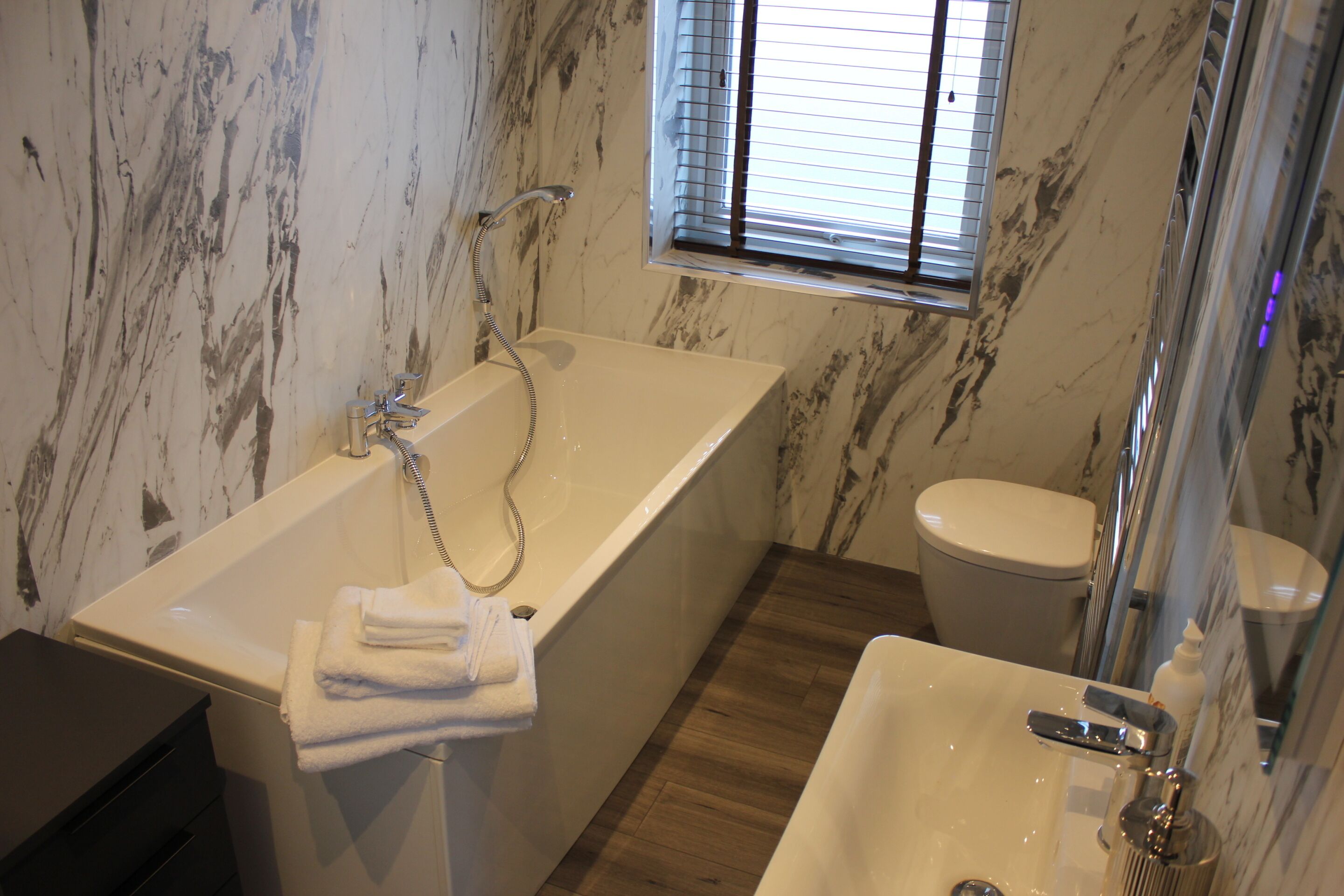Et badeværelse med badekar, toilet og håndvask.