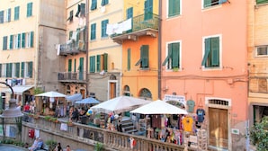 Une rue bordée d’étals de marché en plein air et un immeuble doté de balcons.