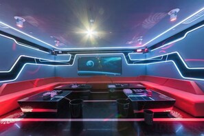 A futuristic lounge area with a curved seating arrangement, a large screen, and ambient lighting. - Minzhong Grand Hotel (Youxi)