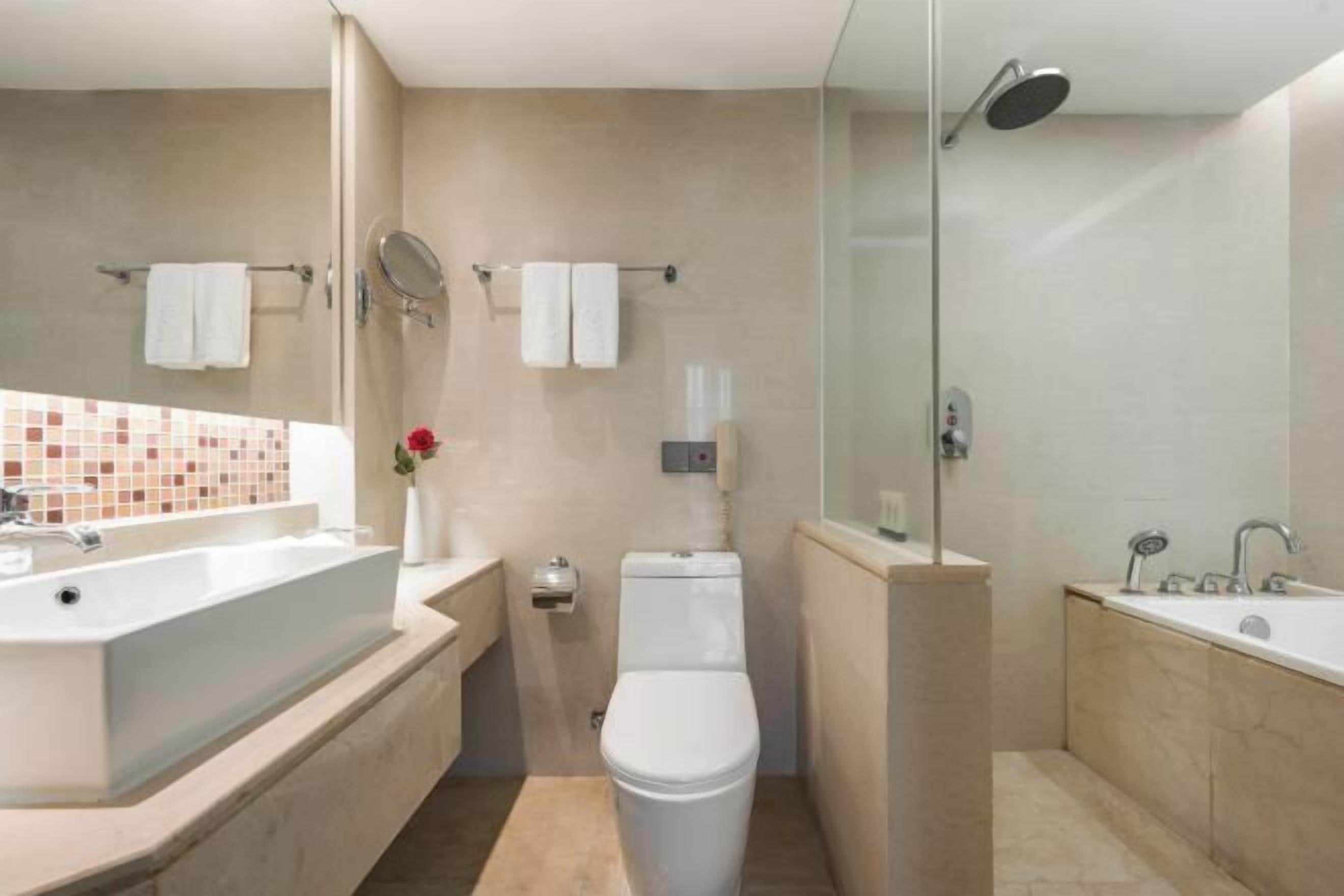 Un bany modern amb una banyera gran, una zona de dutxa separada i un vàter.