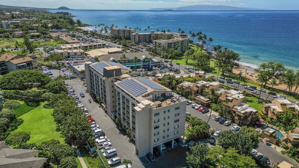 Un hotel con varias edificaciones, estacionamientos y vista a la playa.
