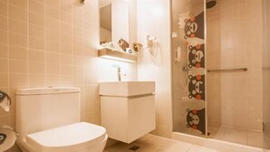 A bathroom with a toilet, a sink, and a shower with a glass door.
