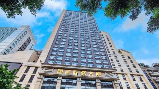 A tall building with multiple floors and a large sign in the center.
