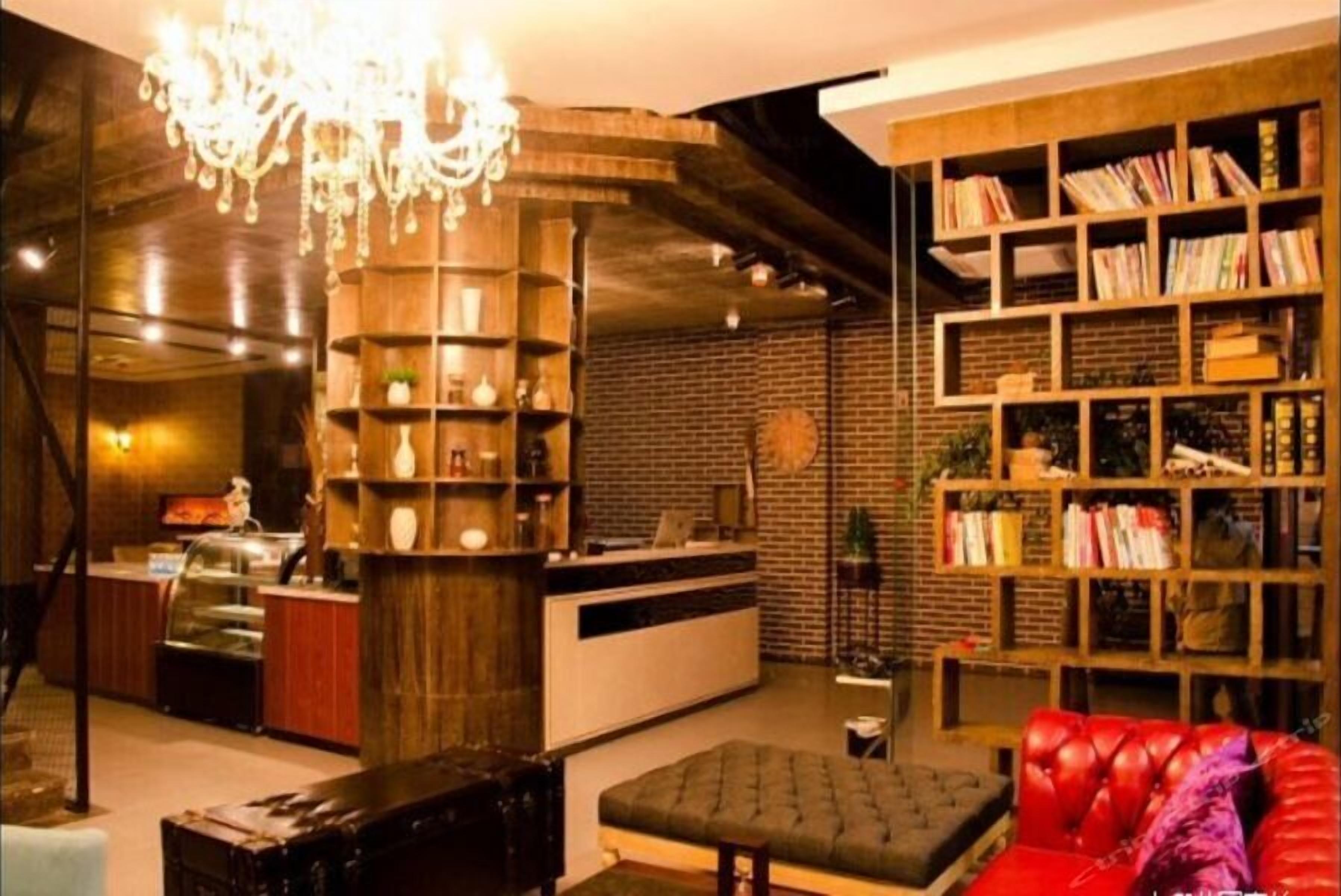 Un interior acogedor con una zona de bar, una estantería y un sofá de cuero rojo.