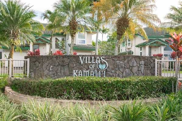Bord van Villas of Kamalii, met een stenen muur en tropische planten.
