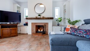A living room with a fireplace, a television, and a sofa.