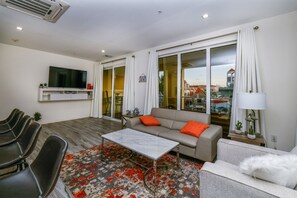 A modern living room with a sofa, coffee table, and chairs. - Stylish 2BR Condo w/ Pool near Palm Beach (Noord)