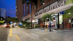 A hotel named "HOTEL BARÍ BUCARAMANGA" with a modern facade, a parking sign, and a well-lit entrance.