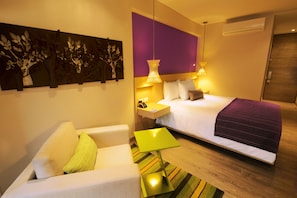 Relax in a serene space with a large bed, nightstands, and a cozy sofa.