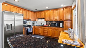A modern kitchen with wooden cabinets, stainless steel appliances, and granite countertops. - Cheerful 3 bedroom. Feels like home. (Chicago)