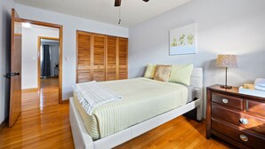A bedroom with a bed, wooden wardrobe, bedside table, and a ceiling fan. - Cheerful 3 bedroom. Feels like home. (Chicago)