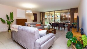Ein modernes Wohnzimmer mit Sofa, Couchtisch und Essbereich.