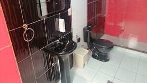 A bathroom with a black sink, a toilet, and a mirror. - RIXAA Hotel (La Paz)