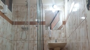 A bathroom with a glass-enclosed shower, a pedestal sink, and a toilet. - RIXAA Hotel (La Paz)