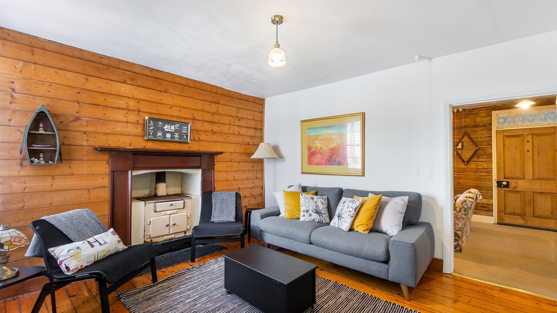 A cozy living room with a fireplace, a sofa set, and a coffee table.