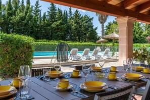An outdoor dining area with yellow and green plates, glasses, and cutlery.