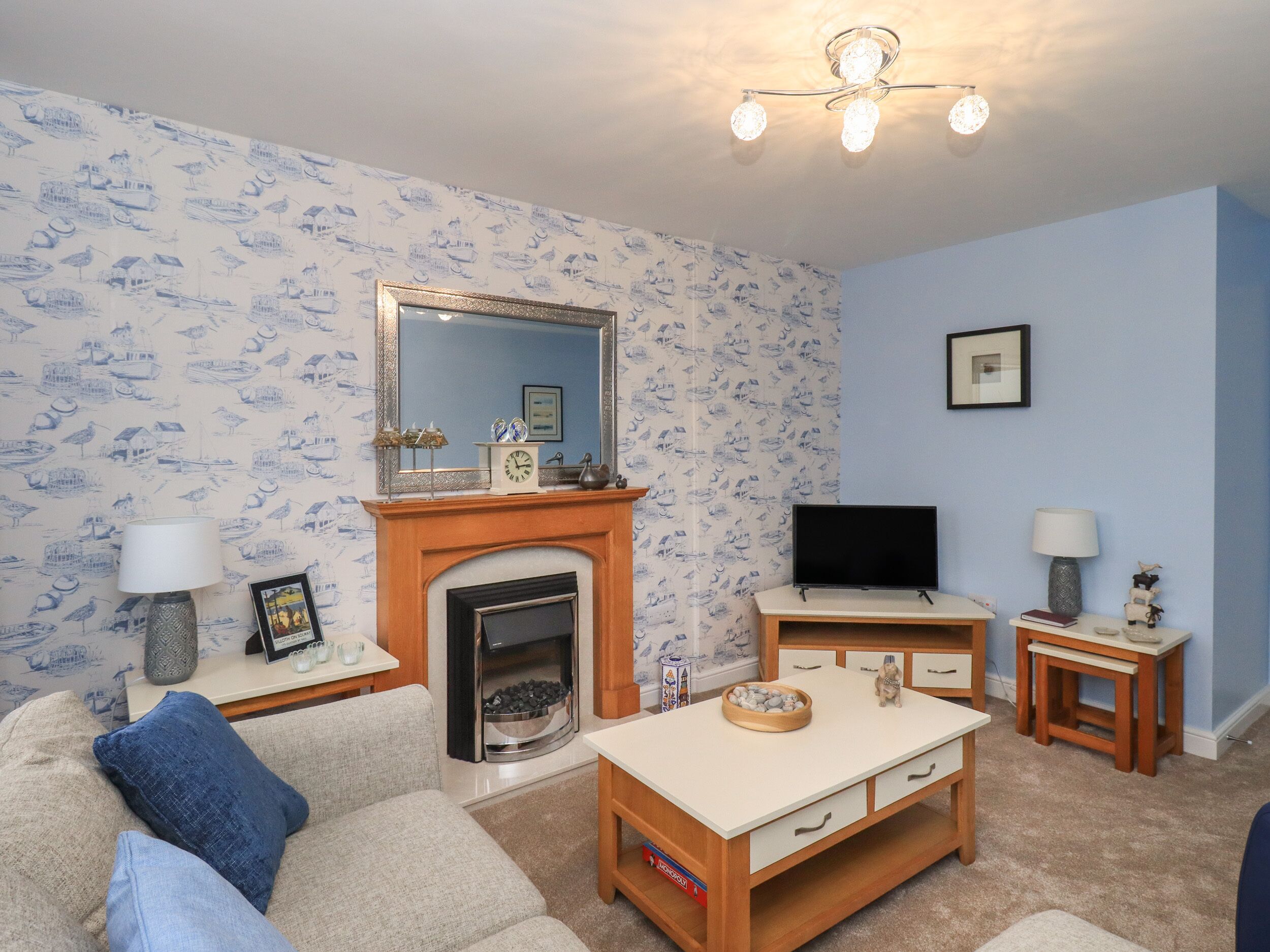 A living room with a fireplace, a television, a small table, and a sofa.