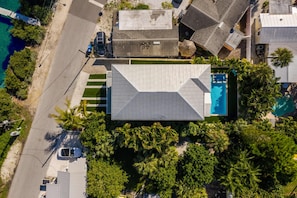 Propiedad residencial con piscina, rodeada de exuberante vegetación y una playa.