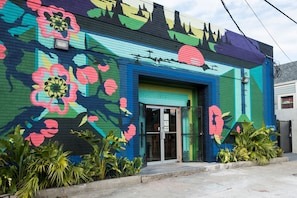 Un edificio con un murale colorato raffigurante motivi floreali e paesaggistici.