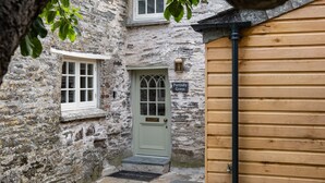 A stone building with a green door, a wooden door, and a sign reading "Porthillly Greys". - Porthilly Greys (Wadebridge)