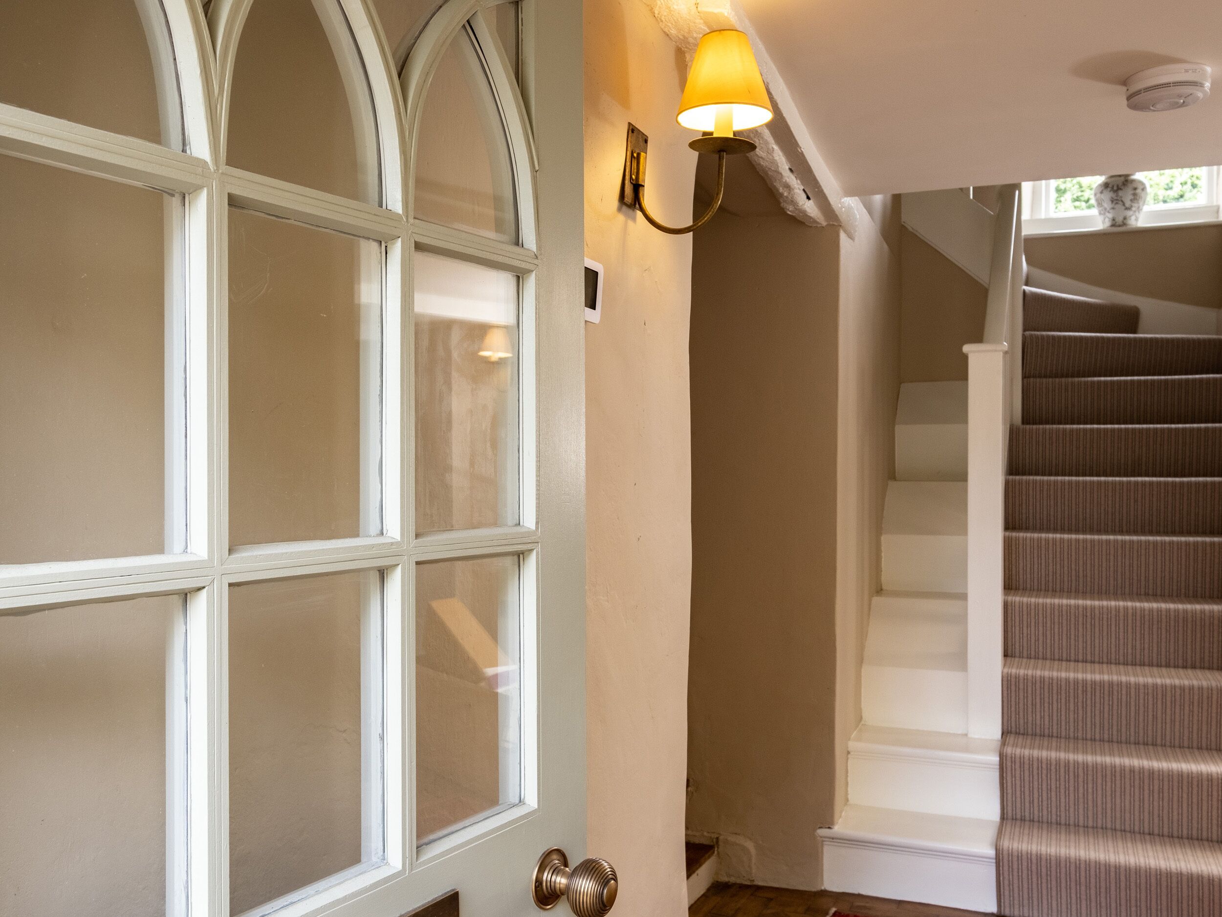 Un escalier muni d’une rampe et d’un luminaire placé au-dessus.