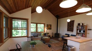 Une cuisine chaleureuse et bien éclairée, avec des meubles en bois, une table à manger et un îlot central intégré.