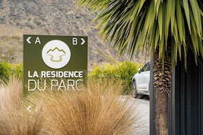 A sign for 'LA RESIDENCE DU PARC' with directional arrows and a symbol.