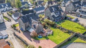 A residential area with stone houses, a paved driveway, and a fenced yard with a small pool. - Tayview (Killin)