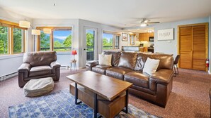A spacious living room with leather sofas, a coffee table, and a dining area with wooden cabinets. - Beautiful decorated Condo, pool, hot tub, great Killington Views - Highridge B6 (Killington)