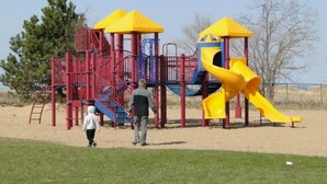 Un parque infantil con un tobogán amarillo y estructuras para escalar.