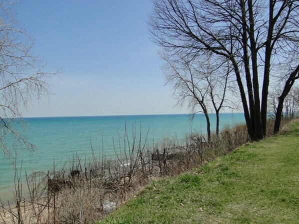Enjoy a serene coastal view with a clear horizon and a natural grassy area.