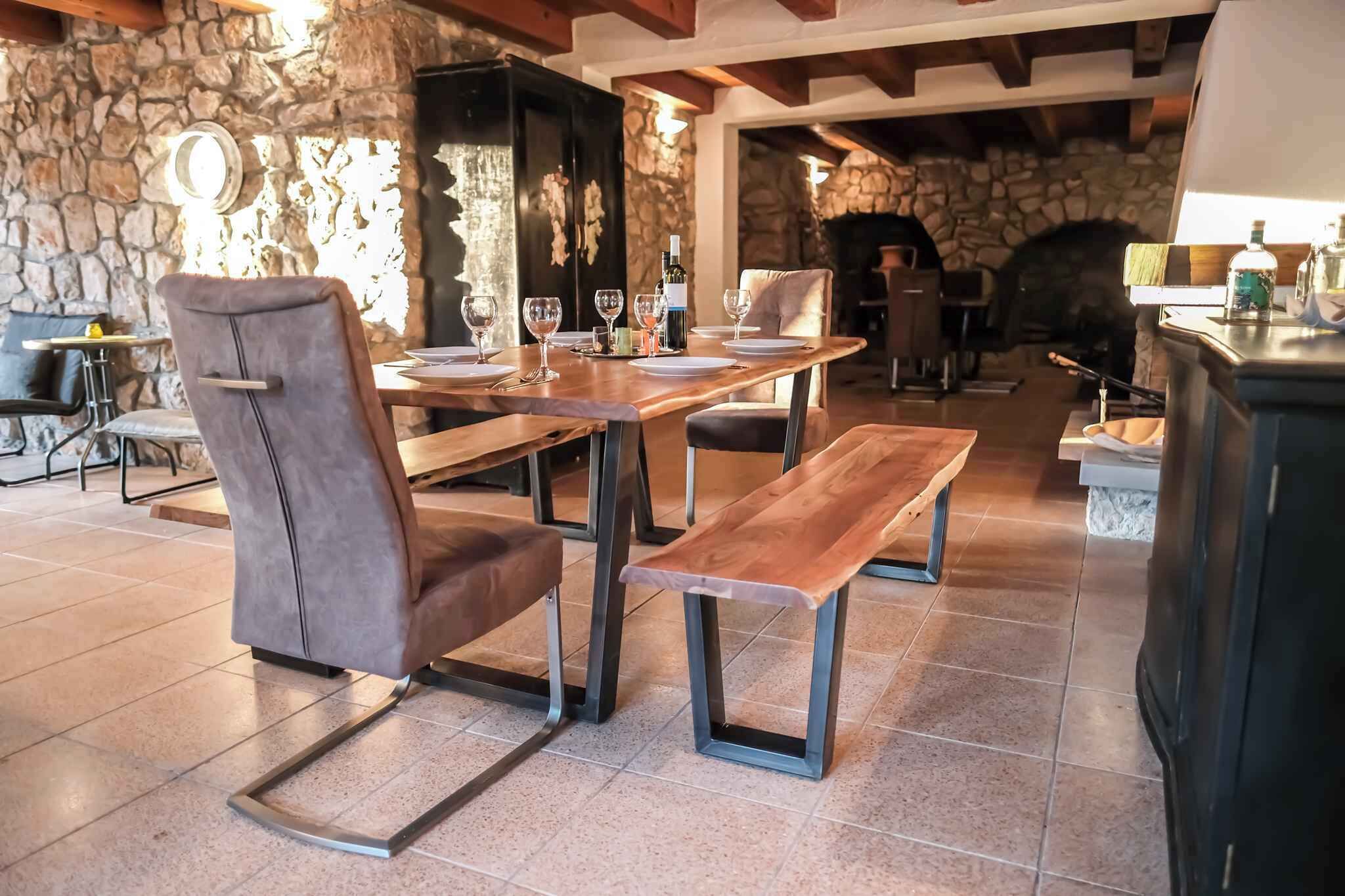 Un comedor rústico con paredes de piedra, mesas de madera y sillas de cuero.