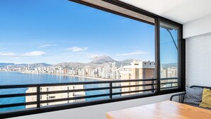 Un balcon offrant une vue sur le paysage urbain de la côte et sur les montagnes.