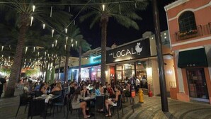 An outdoor dining area with tables and chairs, palm trees, and string lights. - Posturepedic Beds!NearBeach/Airport Spacious BBQ/BAR (Miami)