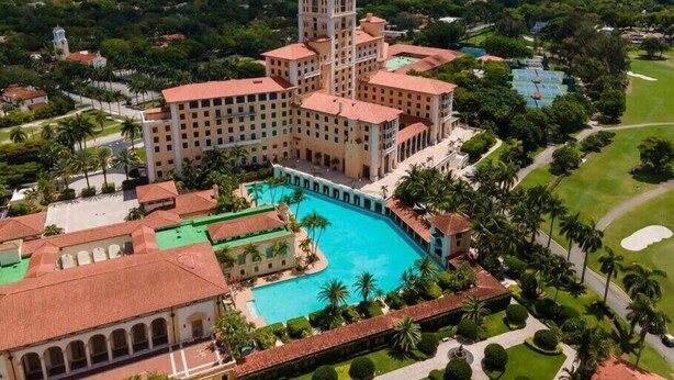A large hotel with a central courtyard, a swimming pool, and a tower. - Posturepedic Beds!NearBeach/Airport Spacious BBQ/BAR (Miami)
