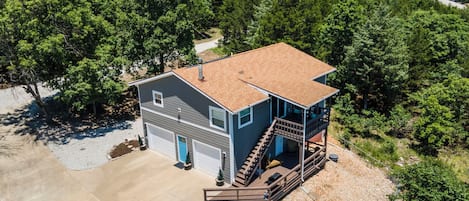 A two-story house with a garage, a covered porch, and a driveway.