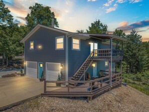 A two-story house with a covered deck and a staircase leading to the upper level. - Secluded Getaway featuring Walking Trail to the Lake, Free Tickets & Minutes from Silver Dollar City (Reeds Spring)