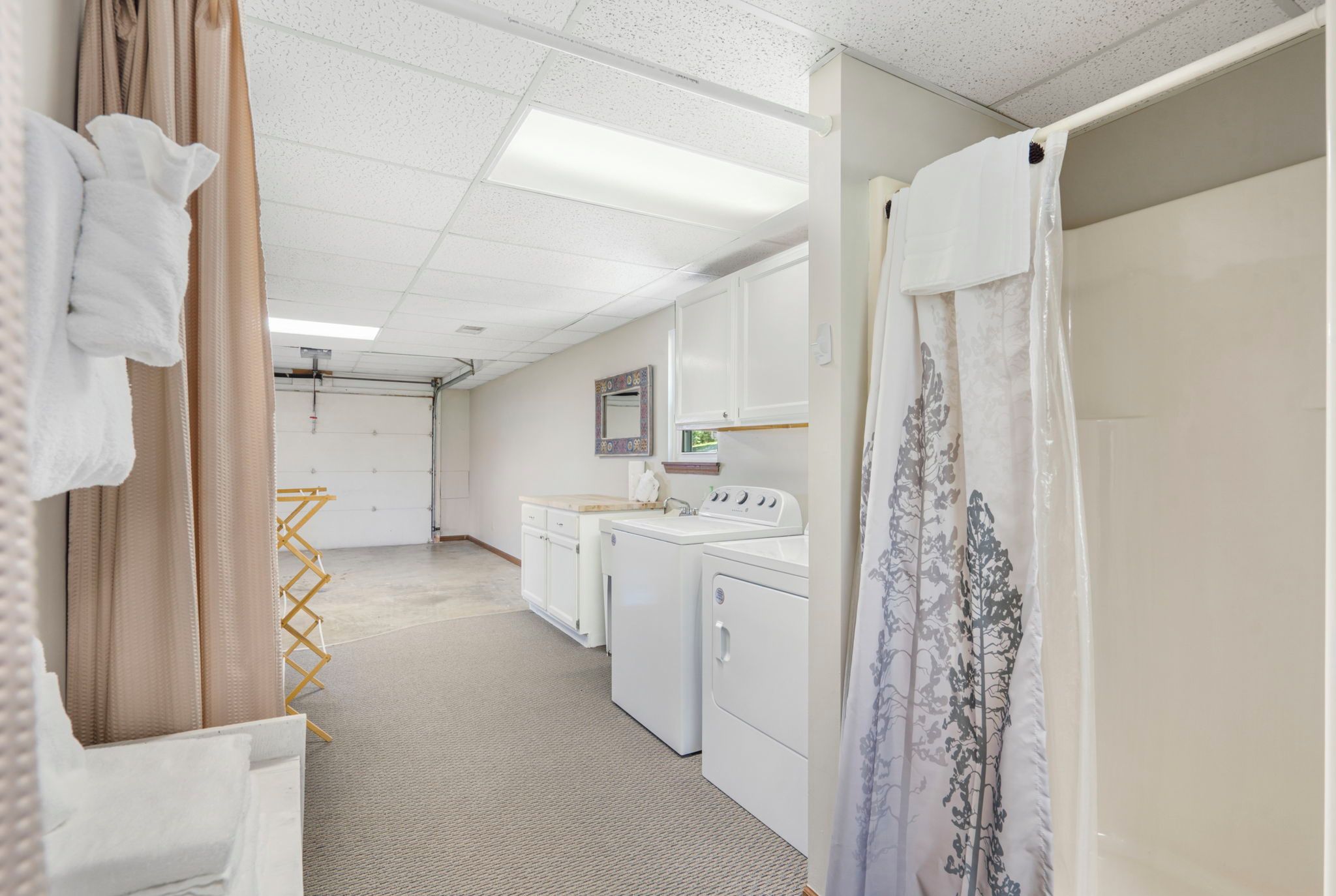 A laundry room with a washing machine, dryer, and ironing station.