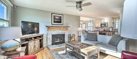 Una sala de estar moderna con chimenea, televisor y sofá.