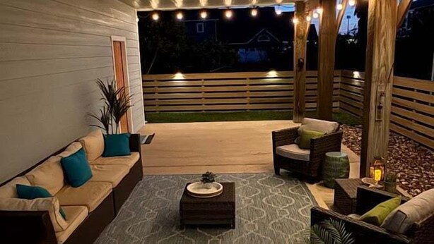 Un espace extérieur aménagé en terrasse, avec un ensemble de canapés, une table basse et des plantes en pot.
