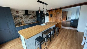 Una cocina con una isla de madera, taburetes altos y un backsplash de pared de ladrillo.