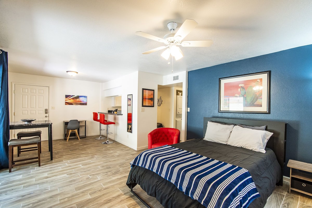 A bedroom with a bed, a desk, a chair, and a ceiling fan.