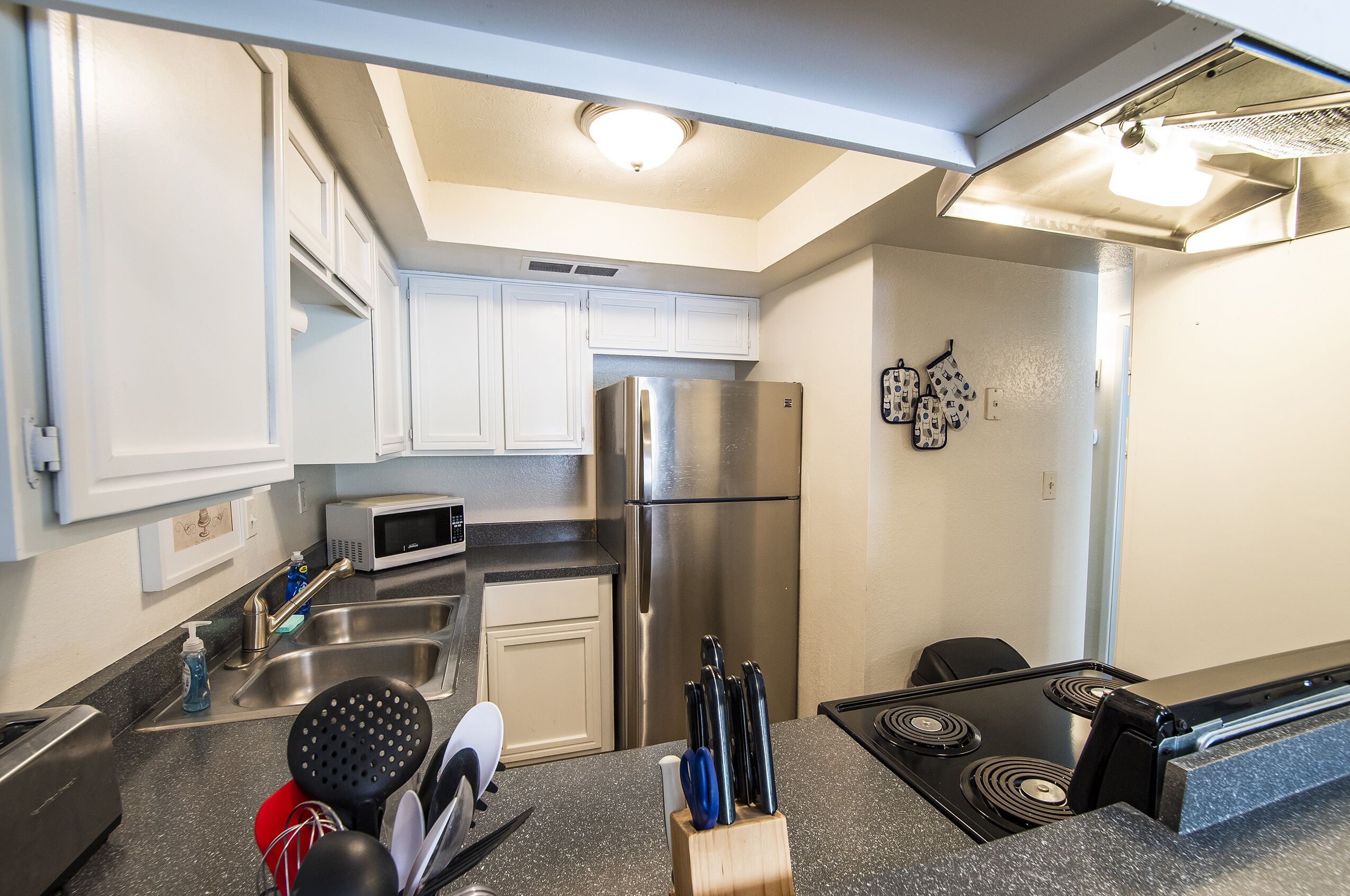 A modern kitchen with stainless steel appliances, a microwave, and a knife block.
