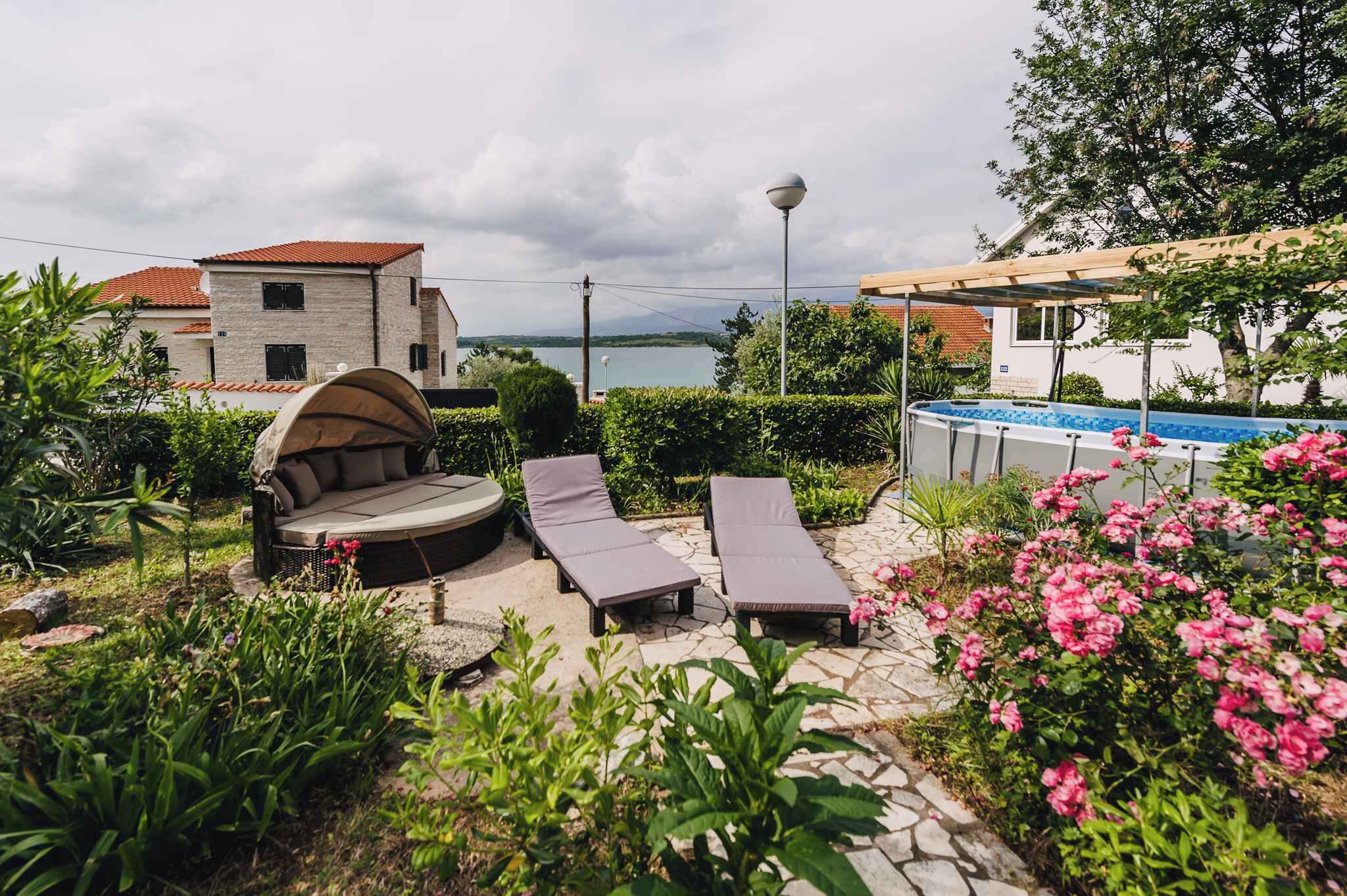 A patio with lounge chairs, a round seating area, and a swimming pool.