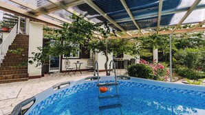 An indoor swimming pool with a tiled floor, a ladder, and a covered roof structure. - Holiday apartment with sea view and pool (Klimno)