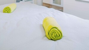 Une chambre à coucher comprenant un lit, une armoire et une porte donnant sur une autre pièce.