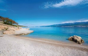 A beach with clear blue water, a rocky shoreline, and distant mountains. - Villa with pool for 6 people (Sveti Vid Dobrinjski)